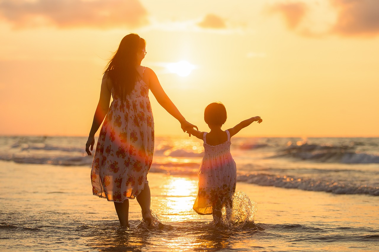 mamma e bambina al tramonto sul mare