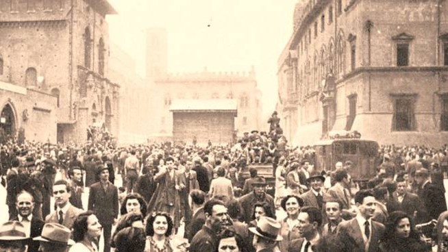 Folla di persone in piazza del Nettuno a Bologna il giorno della Liberazione