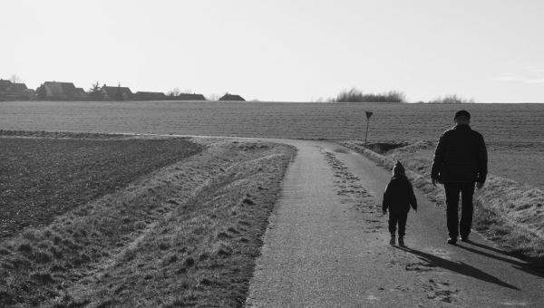 bambino e nonno camminano lungo una strada